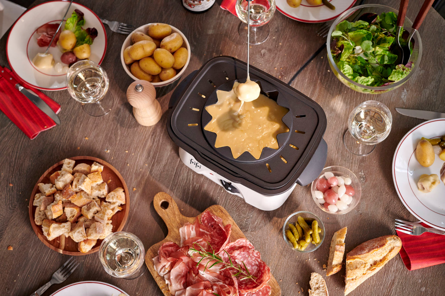 Vue de dessus d'un récipient en acier inoxydable rempli de chocolat fondu, montrant une surface lisse et brillante sur fond blanc.