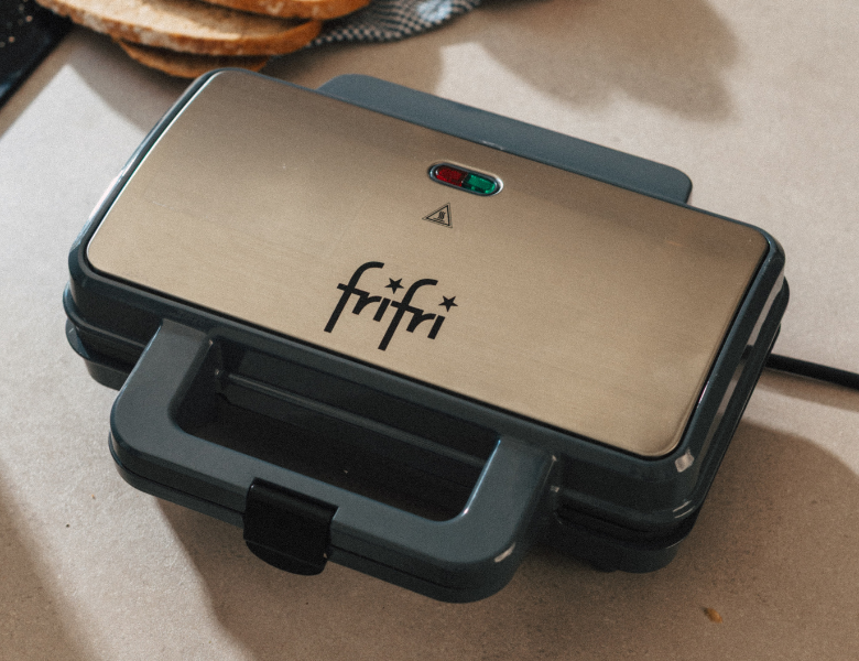 Une presse à sandwich Frifri fermée, posée sur un plan de travail.
