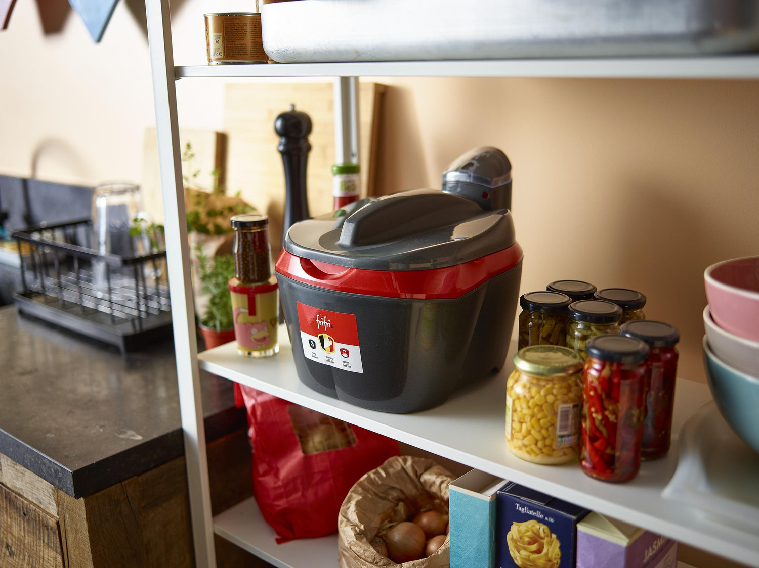 Étagère de cuisine avec autocuiseur et conserves.