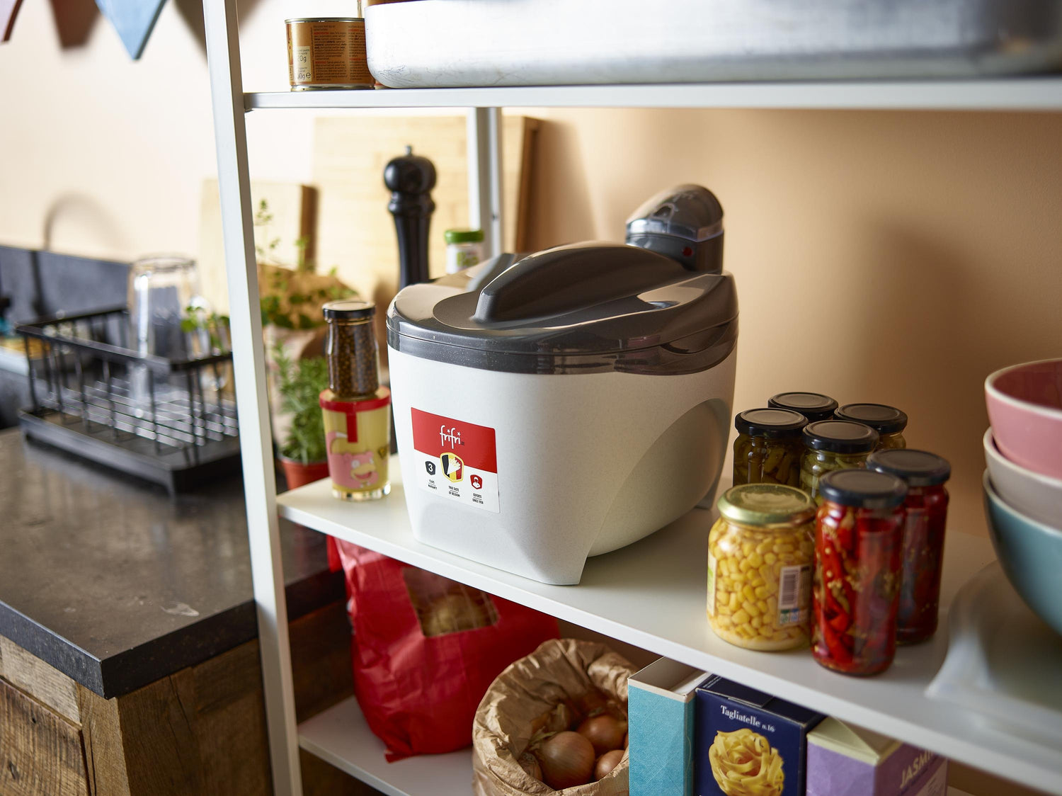 Friteuse sur une étagère, bocaux et aliments divers.