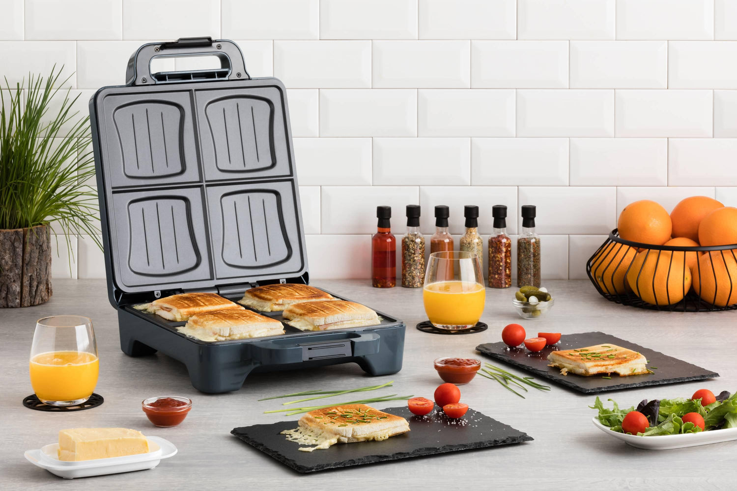 Grille-sandwich ouvert avec sandwichs garnis, sur un comptoir de cuisine.